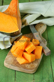 fresh orange pumpkin on the kitchen board