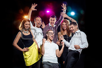 Cheerful group of young people dancing at party