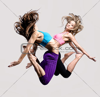 Two beautiful athletic girl jumping 