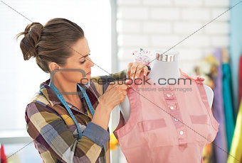 Tailor woman with working on clothes in studio
