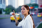 latina businesswoman calling taxi car leaving work