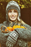 Young woman holding a basket of pumpkins 