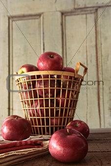 Red apples in metal basket on kitchen table
