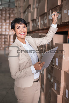 Pretty warehouse manager checking inventory