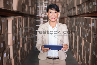 Pretty warehouse manager holding tablet pc