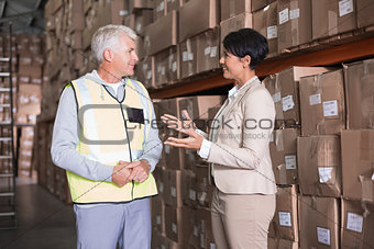 Pretty warehouse manager talking to foreman
