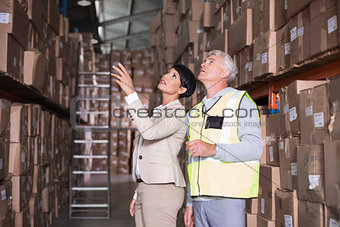 Pretty warehouse manager talking to foreman
