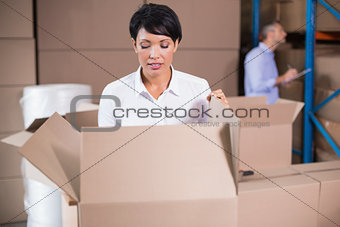 Pretty warehouse manager looking in box