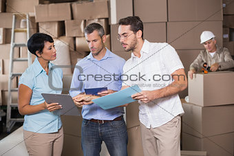 Warehouse workers talking together at work