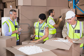 Warehouse workers in yellow vests preparing a shipment