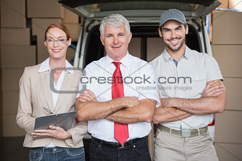 Warehouse managers and delivery driver smiling at camera