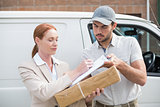 Delivery driver handing parcel to customer outside van