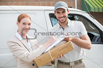 Delivery driver handing parcel to customer outside van