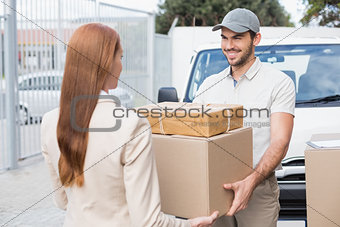 Delivery driver passing parcels to happy customer