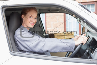 Delivery driver smiling at camera in her van