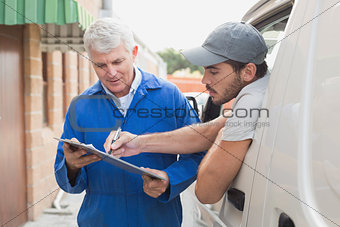 Delivery driver showing customer where to sign