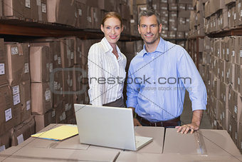 Warehouse team working together on laptop