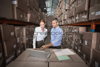 Warehouse team working together on laptop