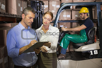 Warehouse team working together with clipboard