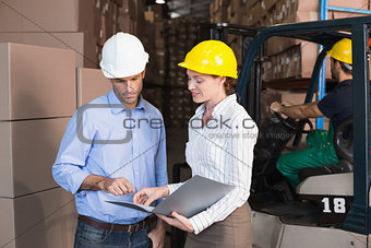Warehouse manager talking with colleague