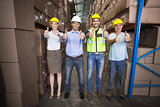 Warehouse team smiling at camera showing thumbs up