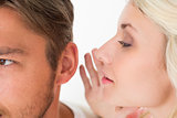 Woman whispering secret into a man's ear
