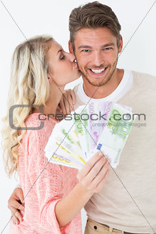 Woman kissing man as she holds banknotes