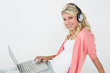 Beautiful woman using laptop while listening to music