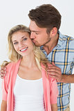 Portrait of young man kissing happy woman