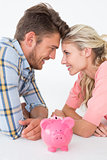 Attractive young couple with piggybank