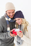 Attractive couple in warm clothing holding gift