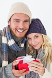 Attractive couple in warm clothing holding gift