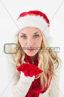 Young woman wearing santa hat as she blows kiss