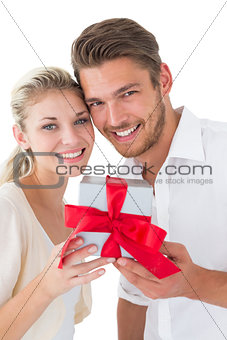 Attractive young couple holding gift