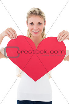 Portrait of smiling young woman holding heart