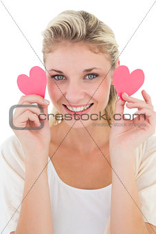 Smiling young woman holding pink hearts