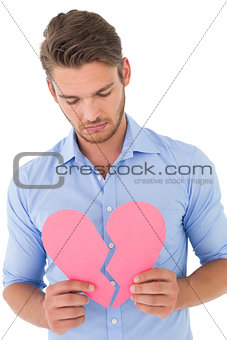 Young man holding broken heart