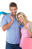 Attractive young couple with shopping bags and credit card