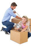 Young couple packing moving boxes