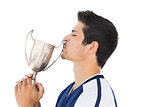 Football player kissing winners cup