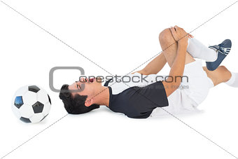 Soccer player lying down and shouting in pain