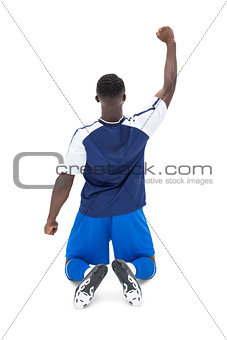 Full length of fit football player cheering