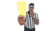Serious referee showing yellow card