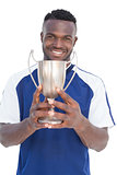 Football player holding winners cup