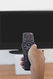 Hand holding remote and changing channel