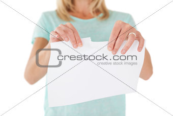 Mid section of woman holding torn sheet of paper