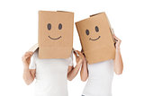 Couple wearing happy face boxes over heads