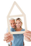 Mature couple looking through house outline