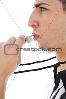 Side view of referee blowing whistle