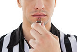 Mid section of referee blowing whistle